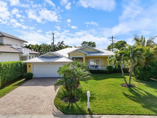 view of front of house featuring a garage, a front lawn, and covered porch