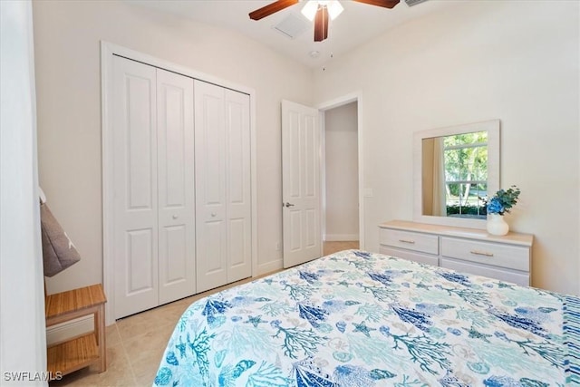 bedroom with ceiling fan, light tile patterned floors, and a closet