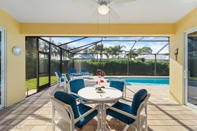 view of swimming pool featuring a lanai, ceiling fan, and a patio area