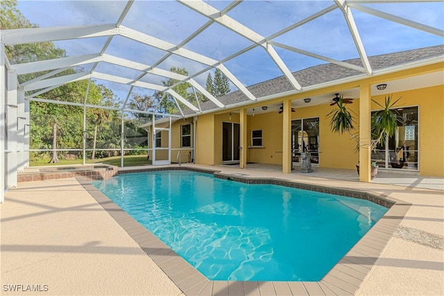 view of pool featuring ceiling fan, a patio area, an in ground hot tub, and glass enclosure