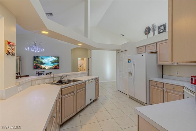 kitchen featuring light brown cabinetry, white appliances, pendant lighting, and sink