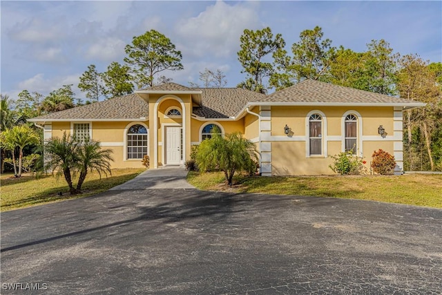 mediterranean / spanish home featuring a front lawn