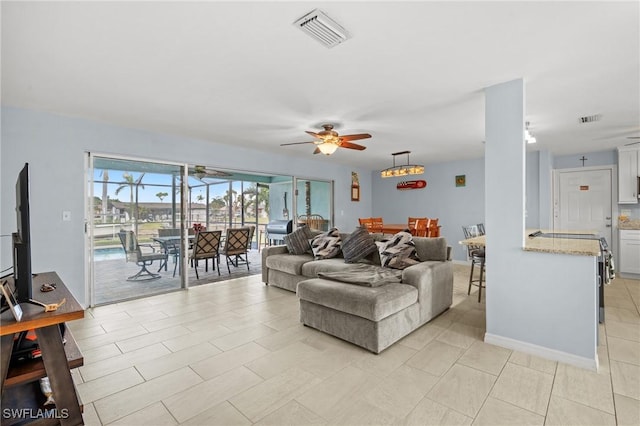 living room with ceiling fan and light tile patterned floors