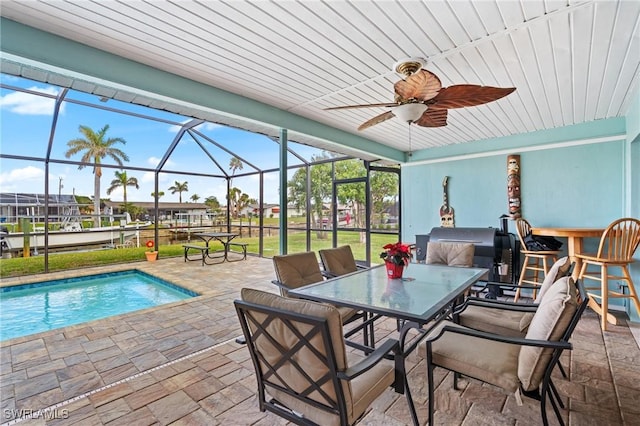 view of pool with a patio, ceiling fan, and a lanai