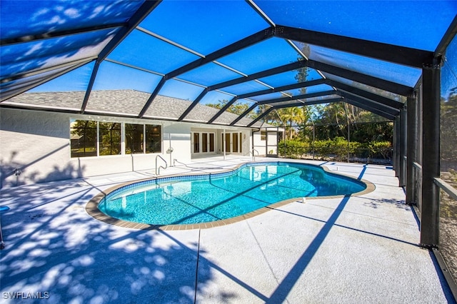 view of swimming pool featuring a lanai and a patio area