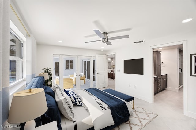 bedroom featuring ceiling fan, ensuite bath, and french doors