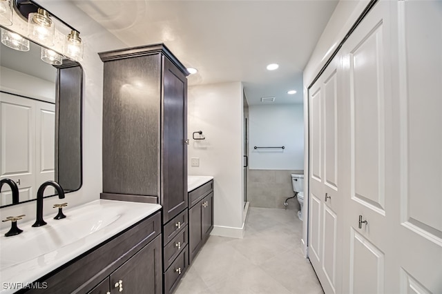 bathroom with tile patterned flooring, vanity, toilet, and a shower with door