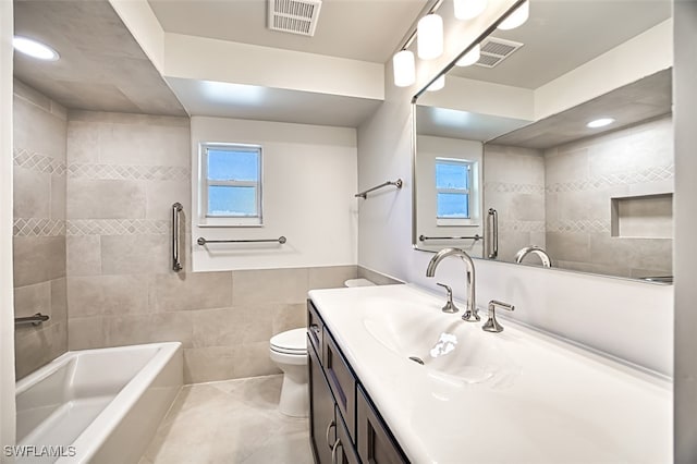 full bathroom with tile patterned floors, vanity, tile walls, toilet, and tiled shower / bath