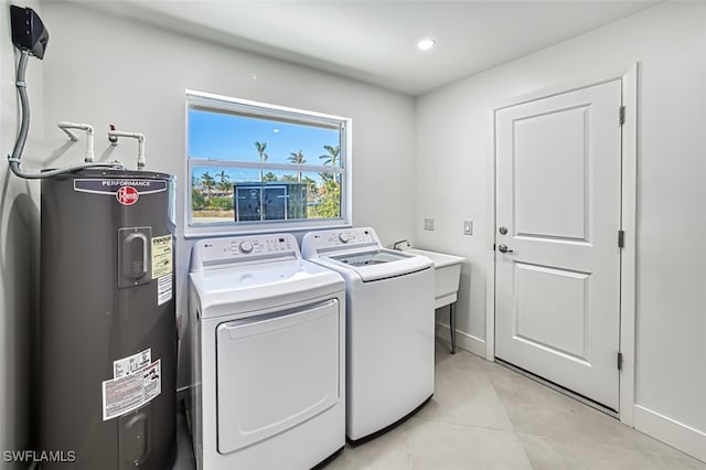 washroom with light tile patterned flooring, washing machine and clothes dryer, and water heater