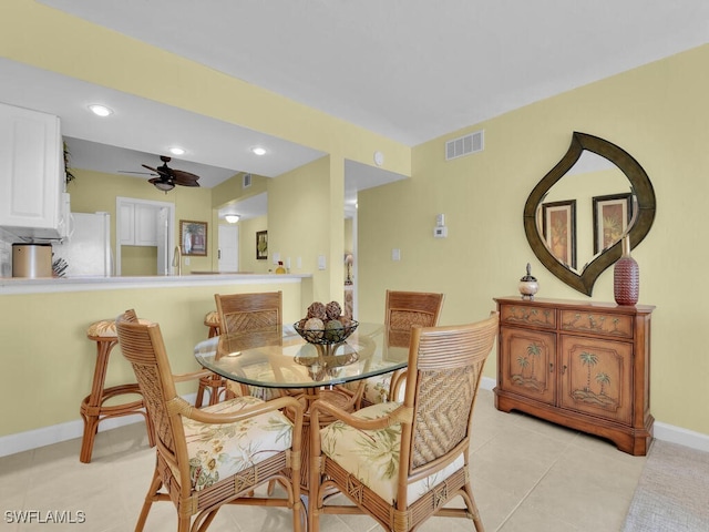 tiled dining space with ceiling fan and sink