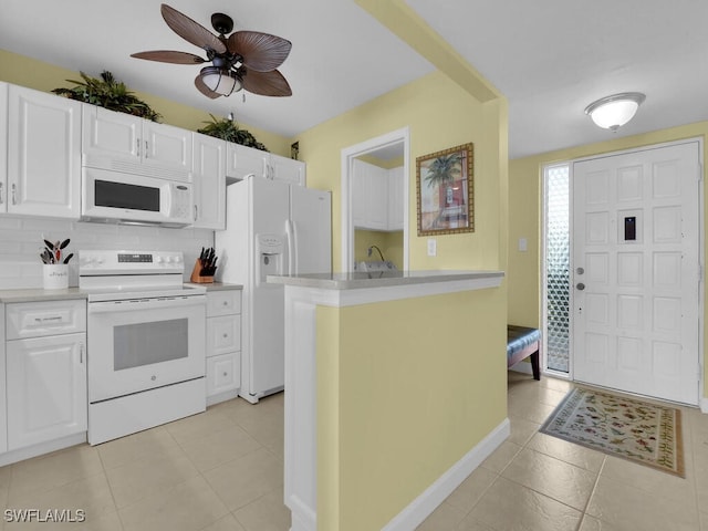 kitchen featuring decorative backsplash, white cabinetry, and white appliances