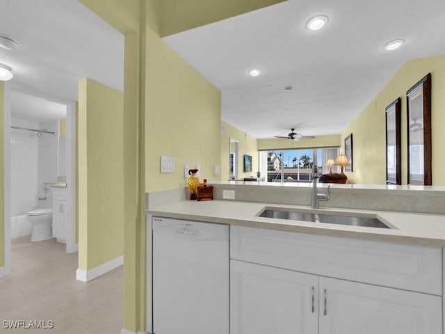 kitchen with ceiling fan, sink, light tile patterned floors, white dishwasher, and white cabinets