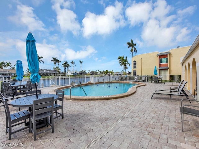 view of pool with a patio and a water view