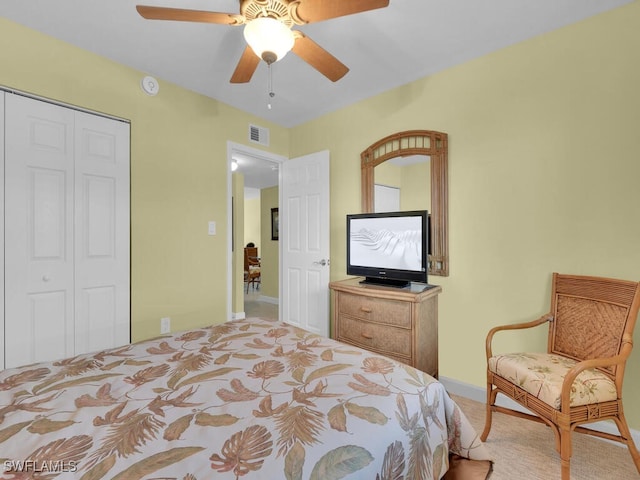 bedroom featuring ceiling fan, light carpet, and a closet