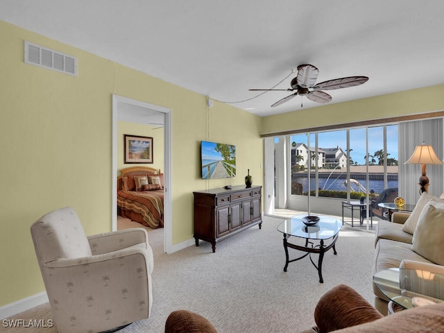 carpeted living room with ceiling fan