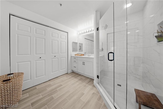 bathroom with vanity and a shower with door