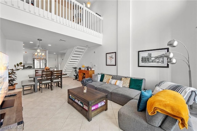 living room featuring ceiling fan, a towering ceiling, and light tile patterned flooring