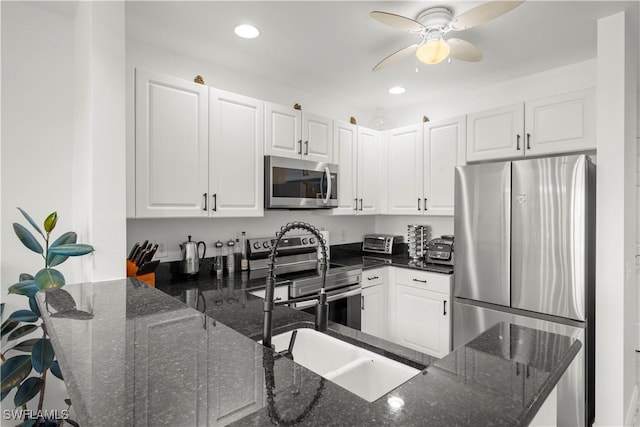 kitchen featuring dark stone counters, white cabinets, and stainless steel appliances