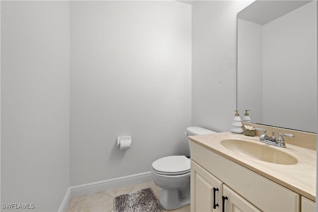 bathroom with toilet, vanity, and tile patterned floors