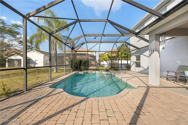 view of swimming pool featuring a patio area, a lanai, and a lawn