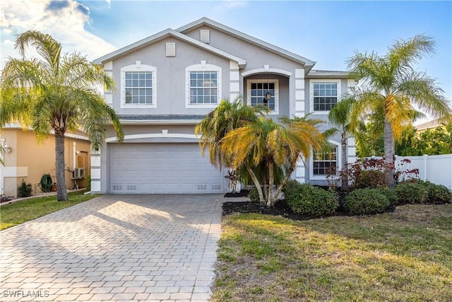 view of front of home with a front lawn, cooling unit, and a garage