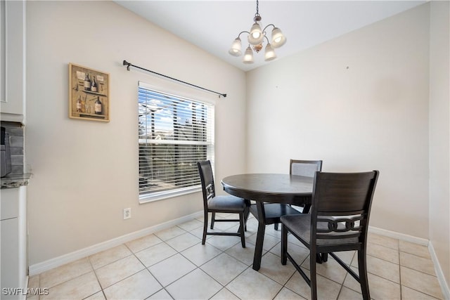 dining space with light tile patterned flooring and a notable chandelier