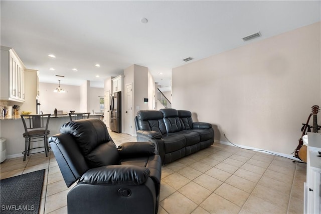 living room with light tile patterned floors and a chandelier