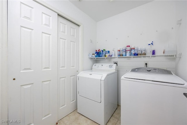 clothes washing area with independent washer and dryer and light tile patterned flooring