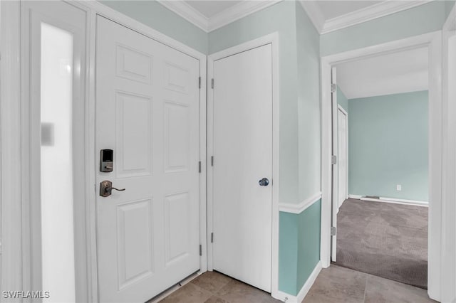 carpeted foyer with ornamental molding