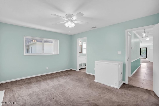 carpeted spare room featuring ceiling fan