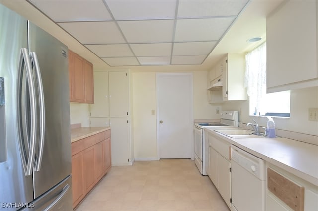 kitchen featuring a paneled ceiling, white cabinetry, sink, and white appliances