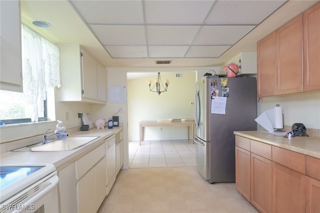 kitchen featuring a drop ceiling, white appliances, sink, hanging light fixtures, and a chandelier