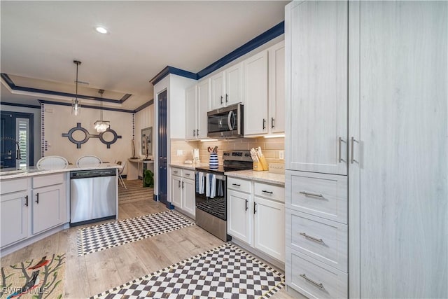 kitchen with white cabinets, stainless steel appliances, and hanging light fixtures