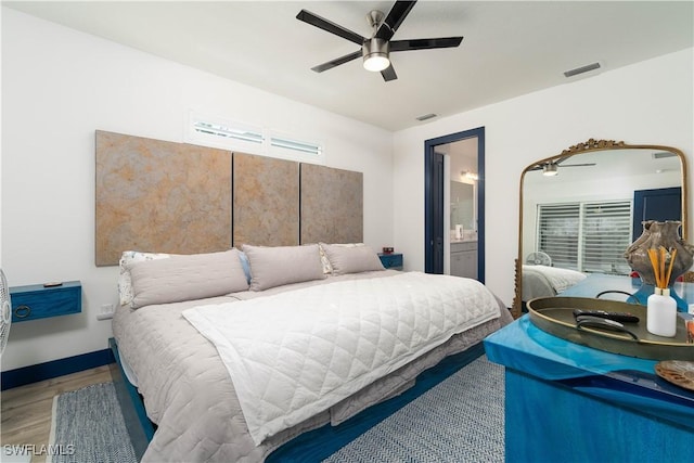 bedroom with hardwood / wood-style flooring, ceiling fan, and ensuite bath