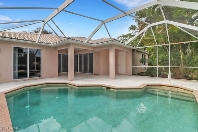 view of pool with glass enclosure and a patio area