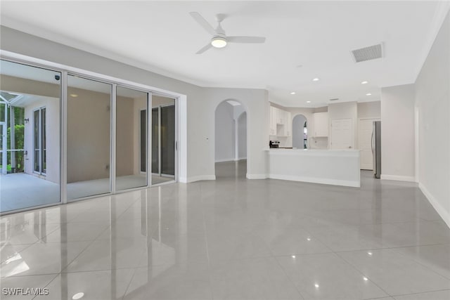 unfurnished living room featuring ceiling fan, ornamental molding, and light tile patterned flooring