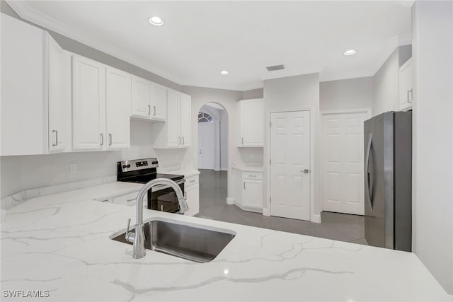 kitchen with appliances with stainless steel finishes, light stone counters, sink, light tile patterned floors, and white cabinets