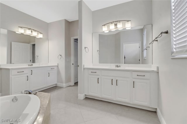 bathroom featuring tile patterned flooring, vanity, and a relaxing tiled tub