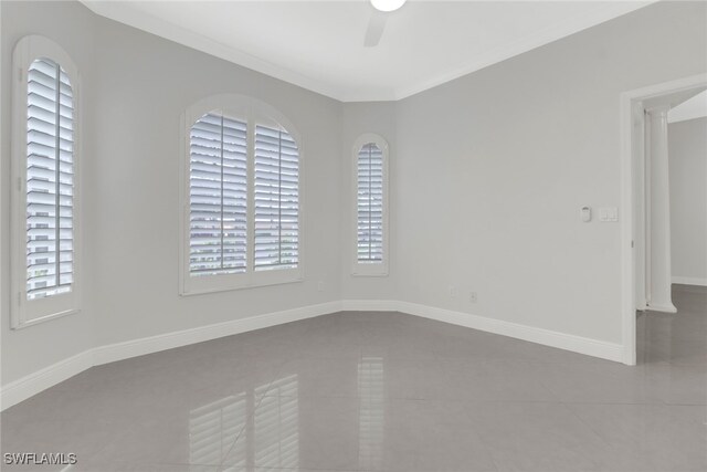 tiled spare room with ornate columns, ceiling fan, plenty of natural light, and ornamental molding