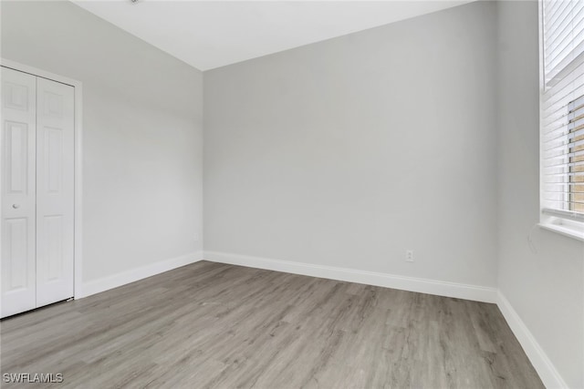 unfurnished bedroom featuring a closet and light wood-type flooring