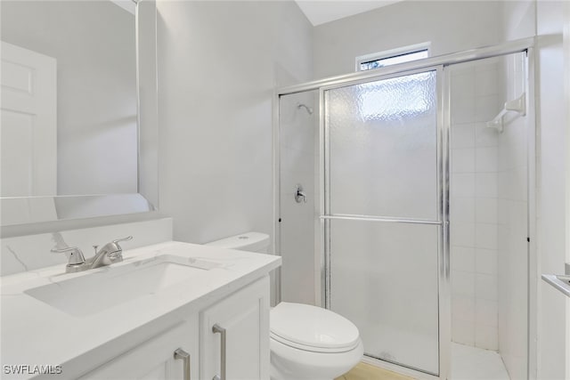 bathroom with vanity, toilet, and a shower with door