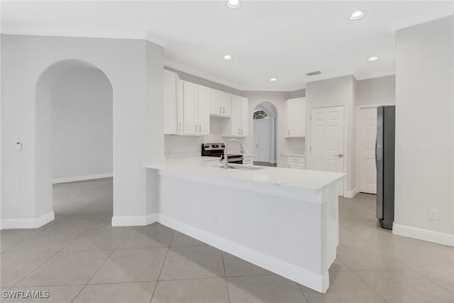 kitchen with white cabinets, light tile patterned floors, sink, and ornamental molding