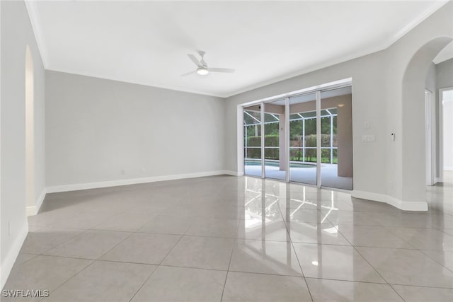 empty room with light tile patterned floors, ceiling fan, and ornamental molding