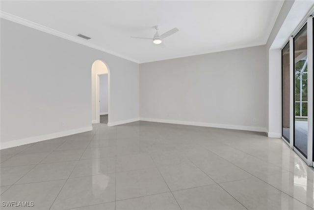 tiled spare room featuring ceiling fan and ornamental molding