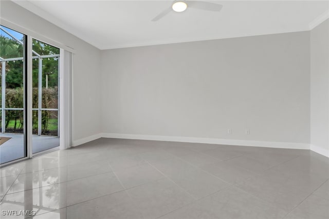 empty room featuring ceiling fan, ornamental molding, and light tile patterned flooring