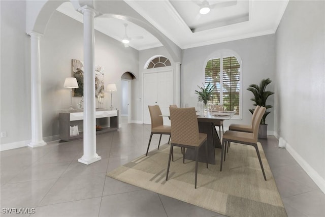 dining room featuring a tray ceiling, ceiling fan, tile patterned flooring, and crown molding