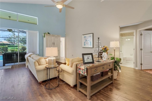 living room with hardwood / wood-style floors, high vaulted ceiling, and ceiling fan