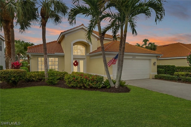 mediterranean / spanish house with a garage and a yard