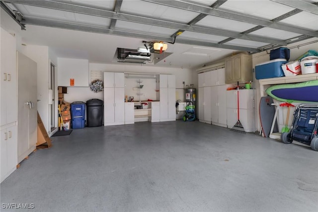 garage with water heater and a garage door opener