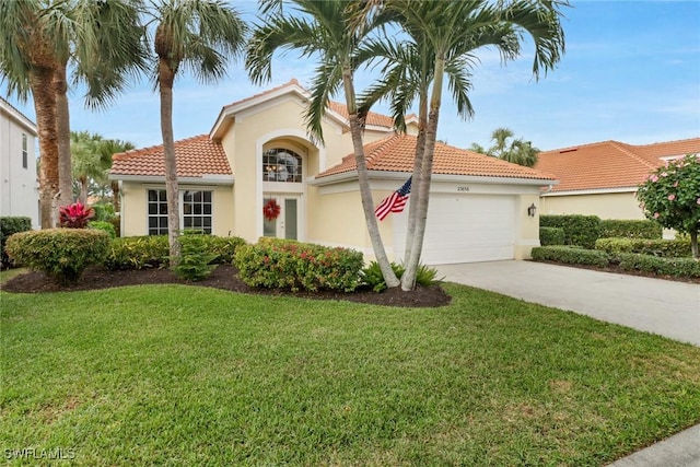 mediterranean / spanish home featuring a garage and a front yard